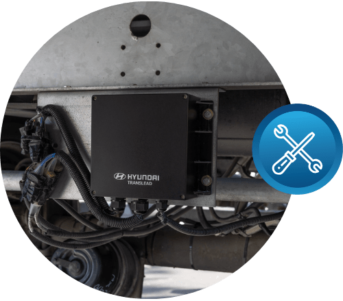 Close-up of a Hyundai Translead HT TEMPS sensor box mounted on the underside of a trailer, with an icon representing equipment and cargo damage, highlighting Hyundai's trailer technology for monitoring and preventing issues like heat buildup.