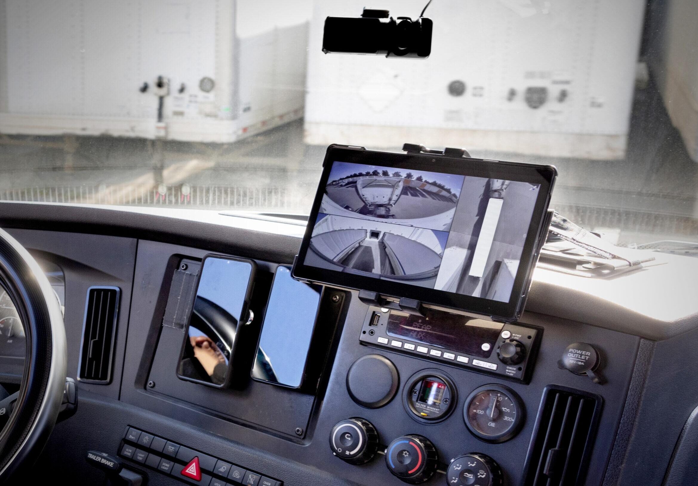 Inside the cab of truck, a tablet displays a 360-degree view from the Hyundai Translead HT LinkVue trailer camera system, showcasing trailer driving visibility and incident recording technology.