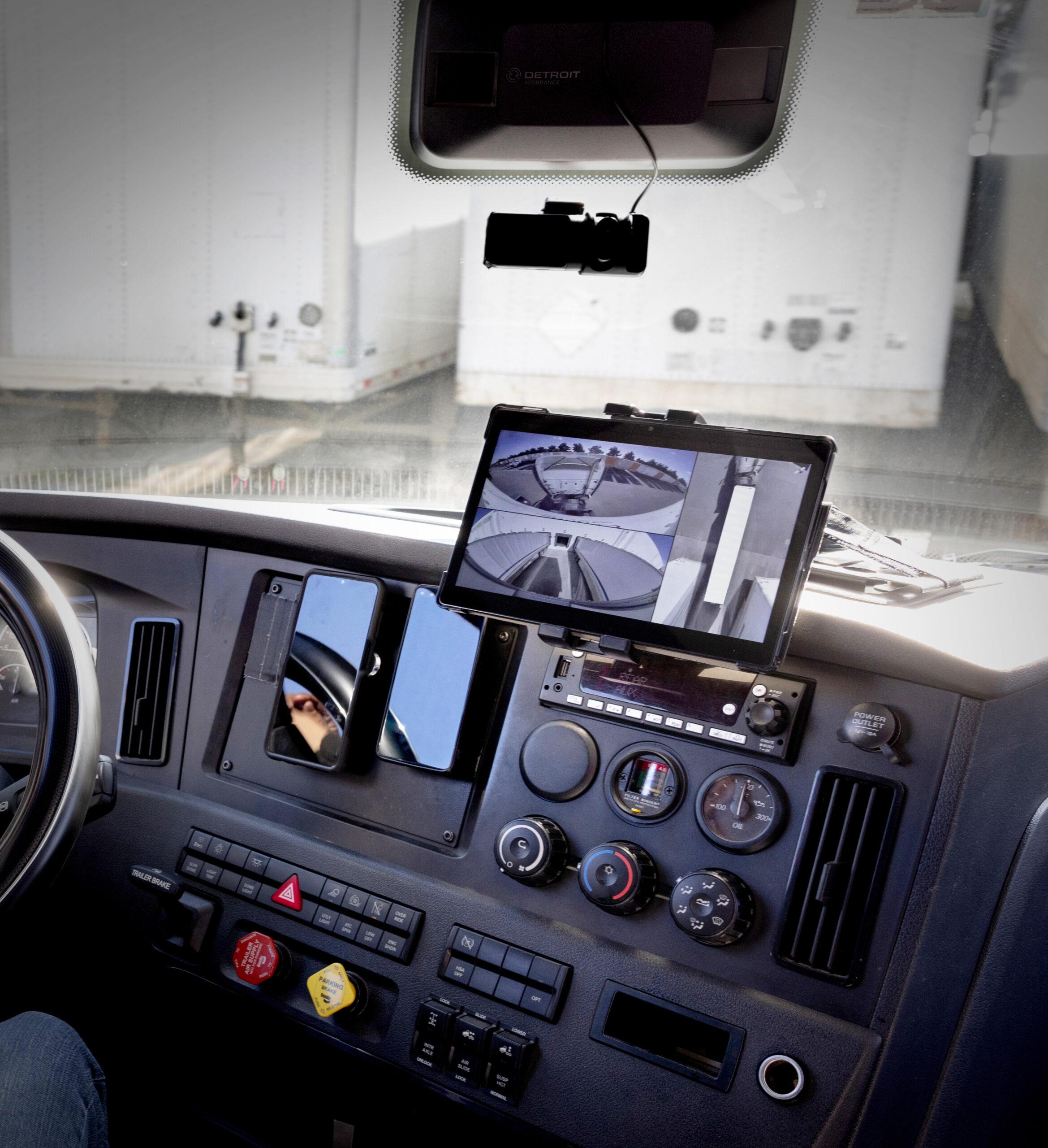 HT LinkVue Image Inside the cab of truck, a tablet displays a 360-degree view from the Hyundai Translead HT LinkVue trailer camera system, showcasing trailer driving visibility and incident recording technology.