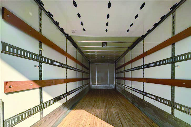 Interior perspective of a Hyundai Translead Anza truck body, showing the E-track system, wood floor, and sturdy walls, highlighting Hyundai's innovative truck body design and technology for secure cargo transport.